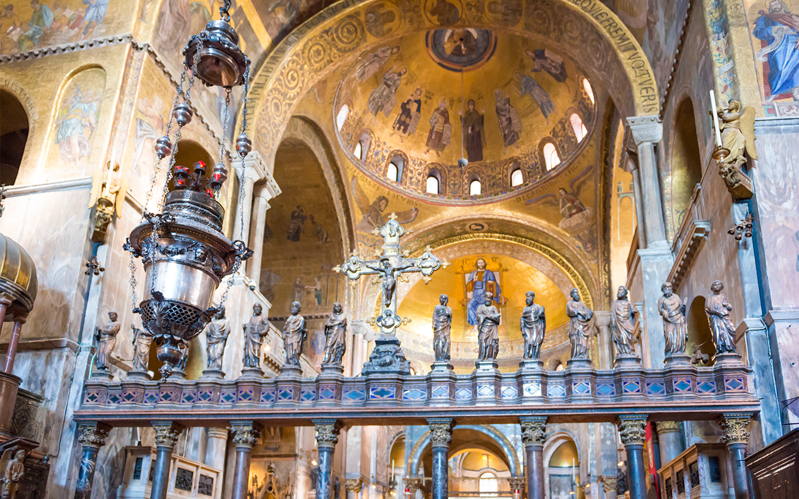 St. Mark's Basilica iconostasis with ornate gold mosaics and religious figures in Venice, Italy.