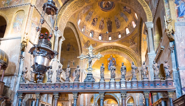 St. Mark's Basilica iconostasis with ornate gold mosaics and religious figures in Venice, Italy.