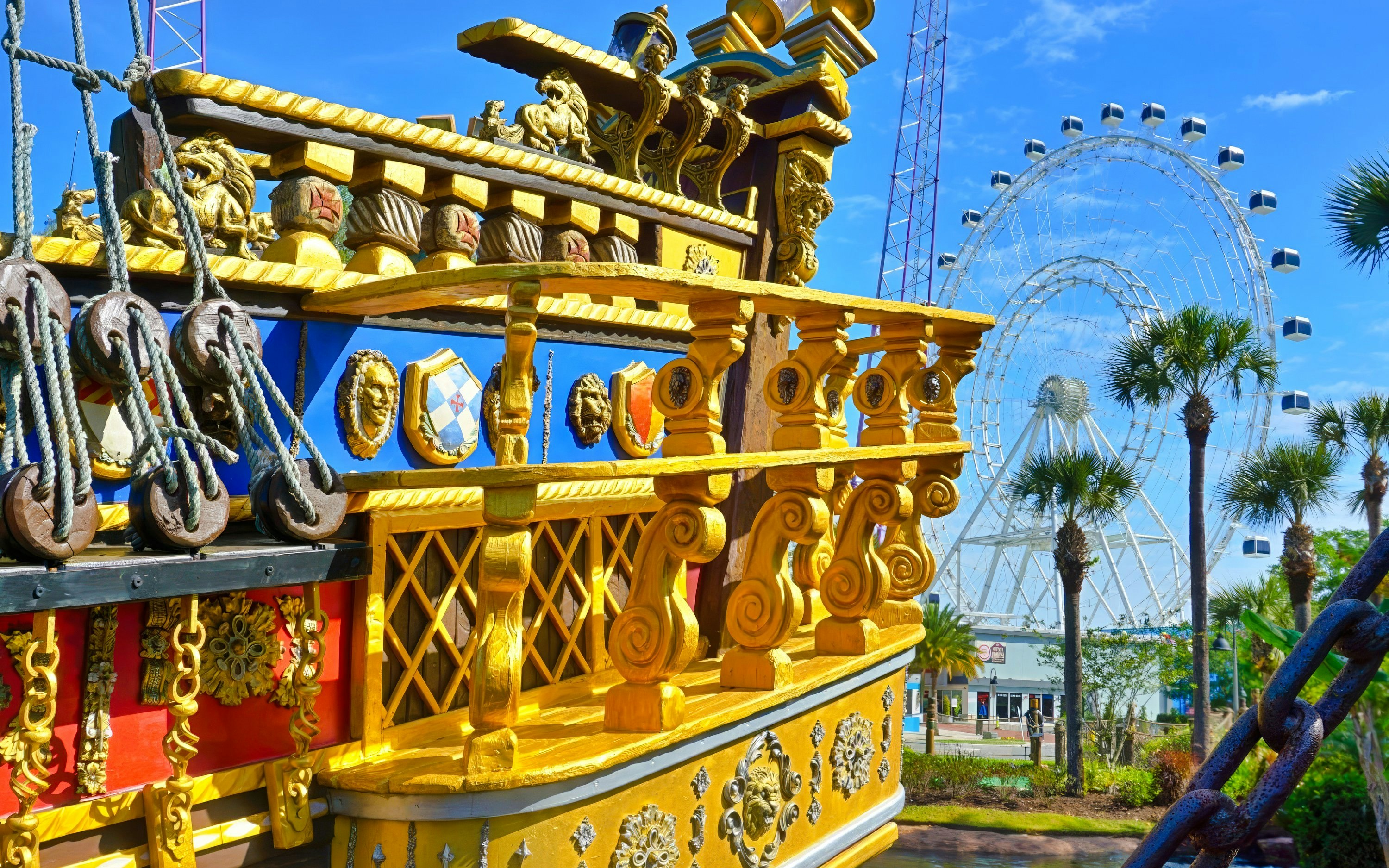Pirate ship detail at Pirate's Cove Adventure Golf with Ferris wheel in the background.