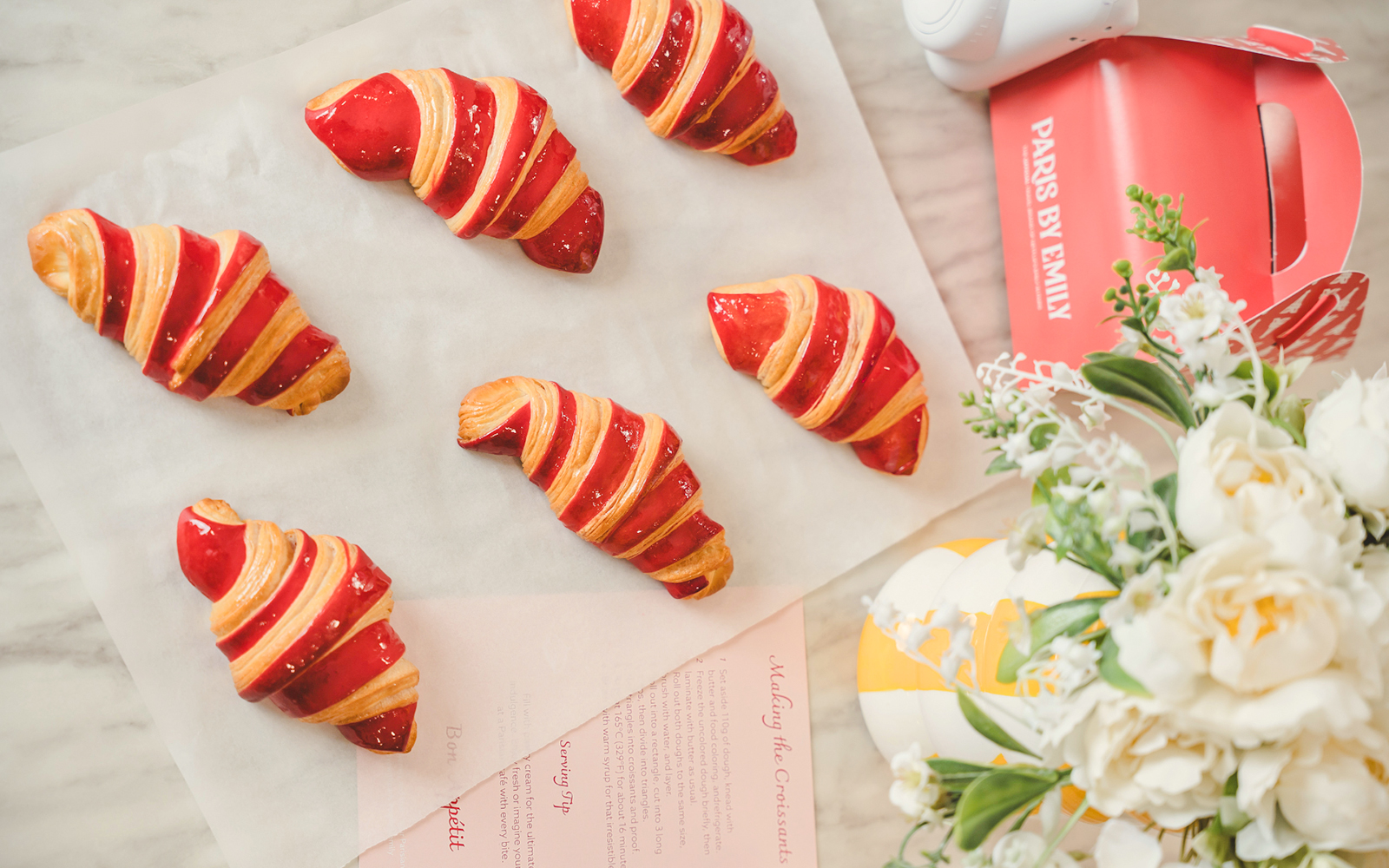 Red-striped croissants on parchment paper from Emily in Paris Croissant-Making Workshop.