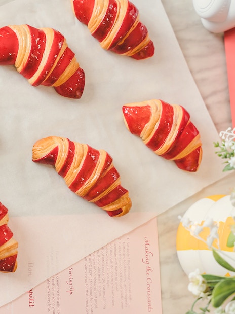 Red-striped croissants on parchment paper from Emily in Paris Croissant-Making Workshop.