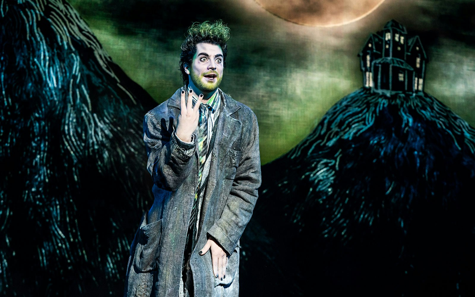 Performer in Beetlejuice stage show, West End, with eerie backdrop.