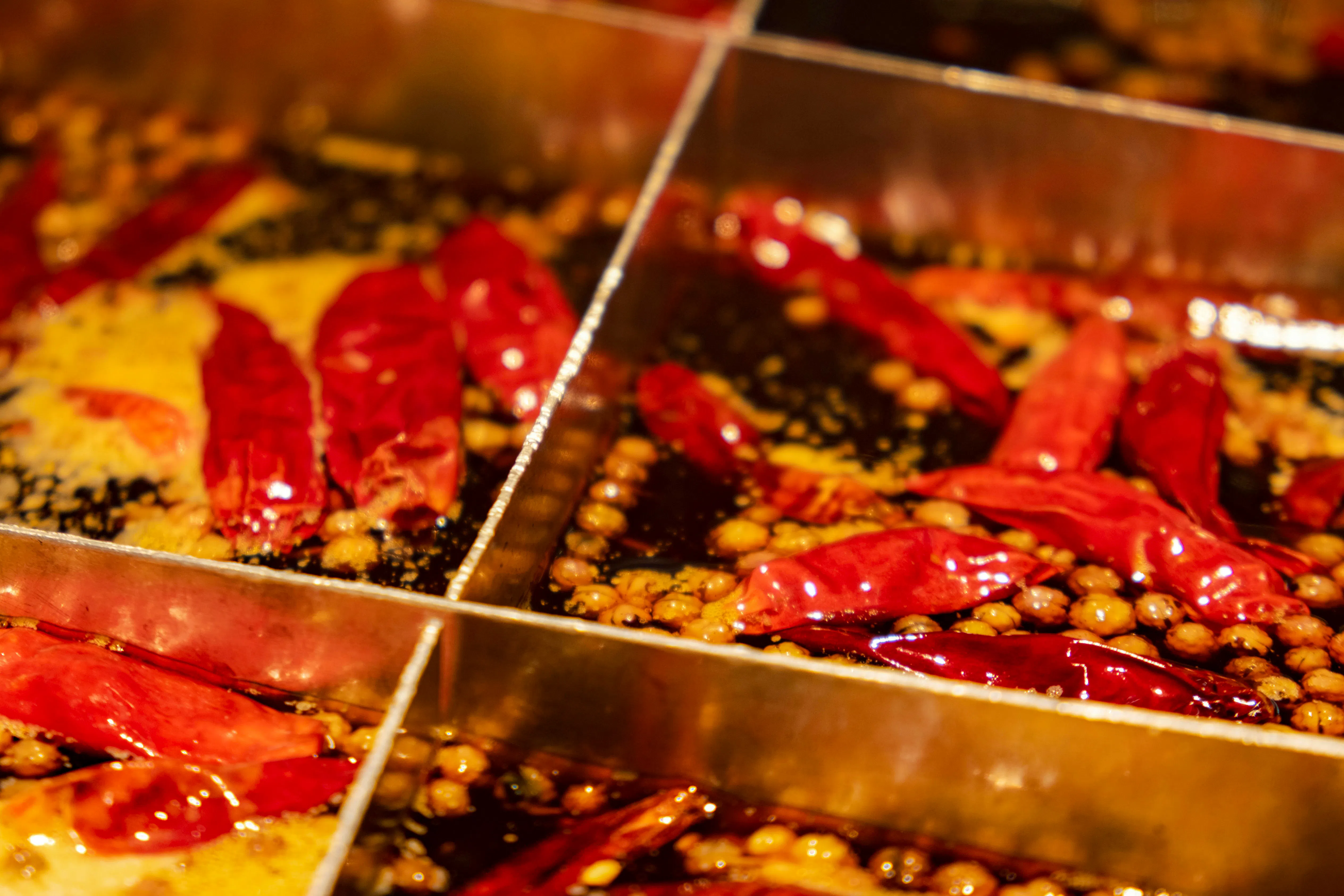 Chongqing hot pot with red chili peppers and spices in simmering broth.