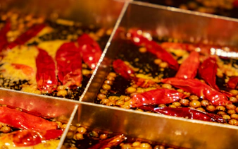 Chongqing hot pot with red chili peppers and spices in simmering broth.
