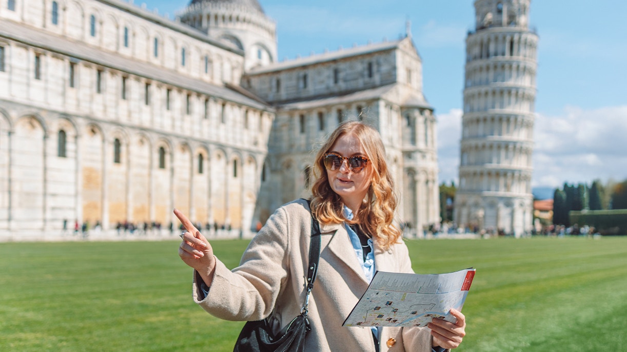 Tour guide explaining Pisa Cathedral and Leaning Tower of Pisa, Italy.