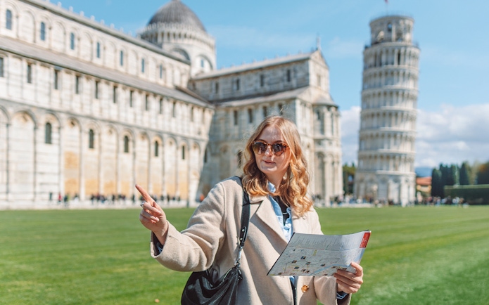 Tour guide explaining Pisa Cathedral and Leaning Tower of Pisa, Italy.