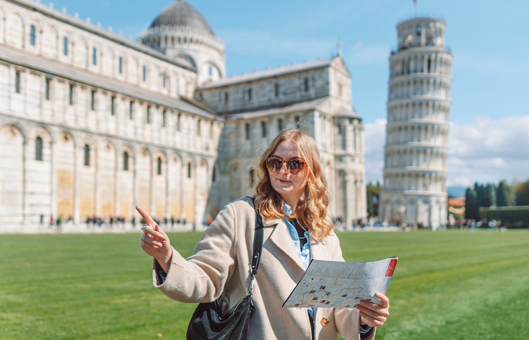 Tour guide explaining Pisa Cathedral and Leaning Tower of Pisa, Italy.