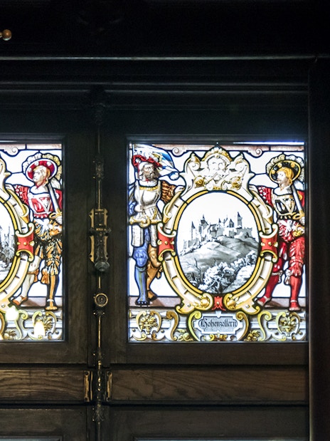 Stained glass windows depicting historical scenes inside Peles Castle, Sinaia.