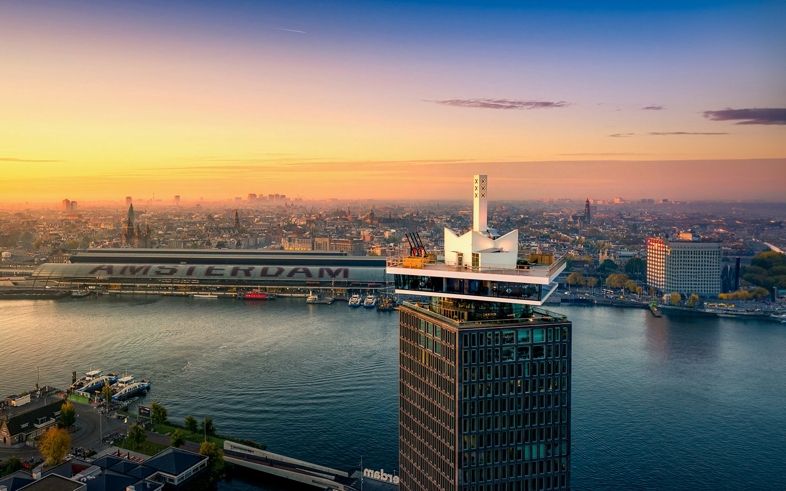 ADAM Lookout tower with panoramic view of Amsterdam skyline at sunset.