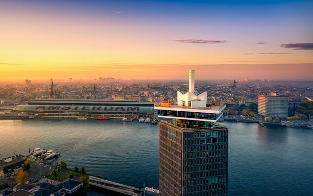 ADAM Lookout tower with panoramic view of Amsterdam skyline at sunset.