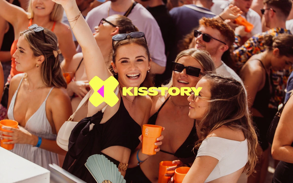 Partygoers enjoying Kisstory event at O Beach Ibiza with drinks and music.