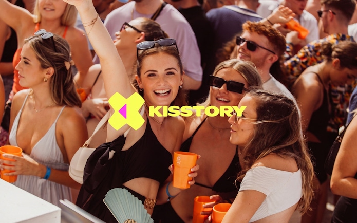 Partygoers enjoying Kisstory event at O Beach Ibiza with drinks and music.