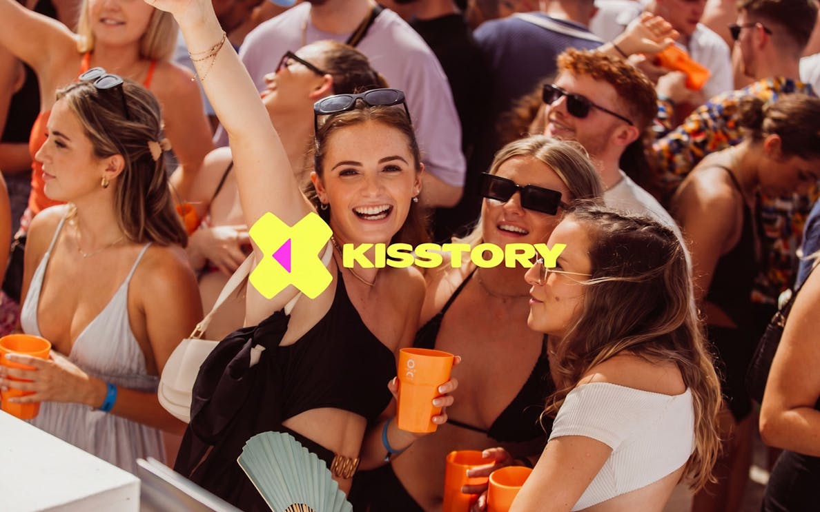 Partygoers enjoying Kisstory event at O Beach Ibiza with drinks and music.
