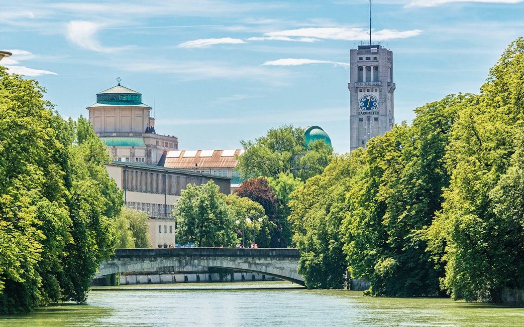 Munich cityscape with Isar River, bridge, and historic buildings in the inner area.