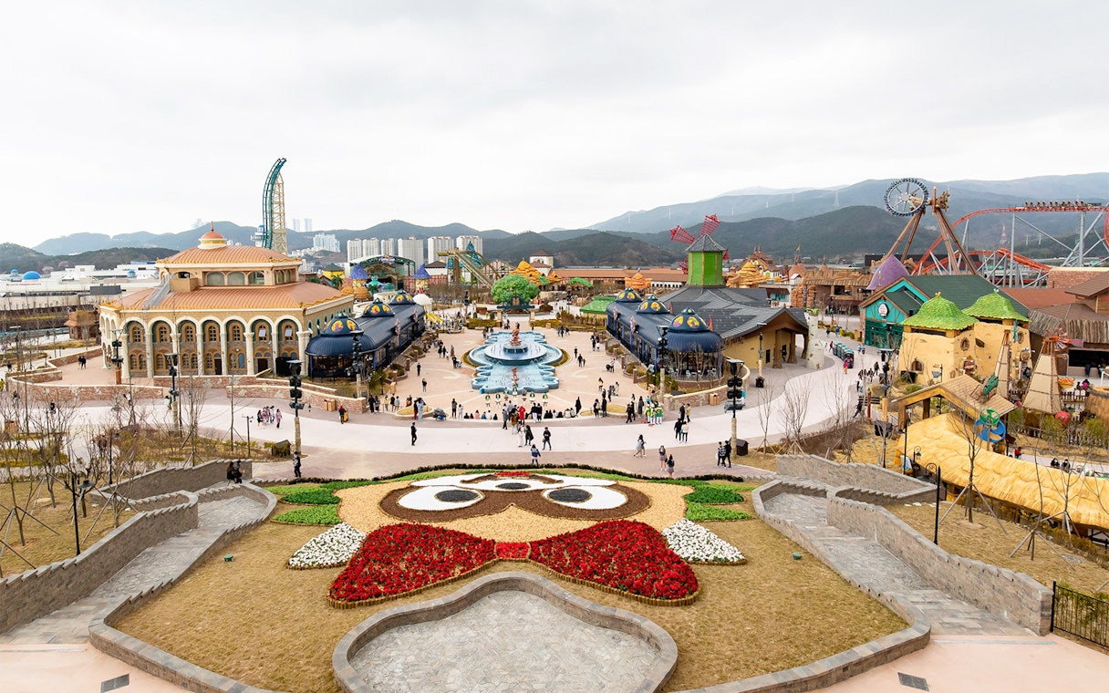 Lotte World Adventure Busan theme park with colorful buildings and a central fountain.