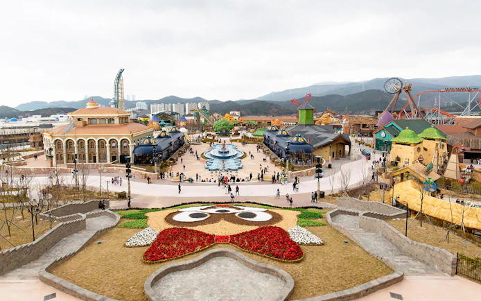 Lotte World Adventure Busan theme park with colorful buildings and a central fountain.