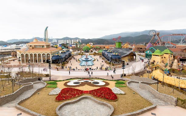 Lotte World Adventure Busan theme park with colorful buildings and a central fountain.