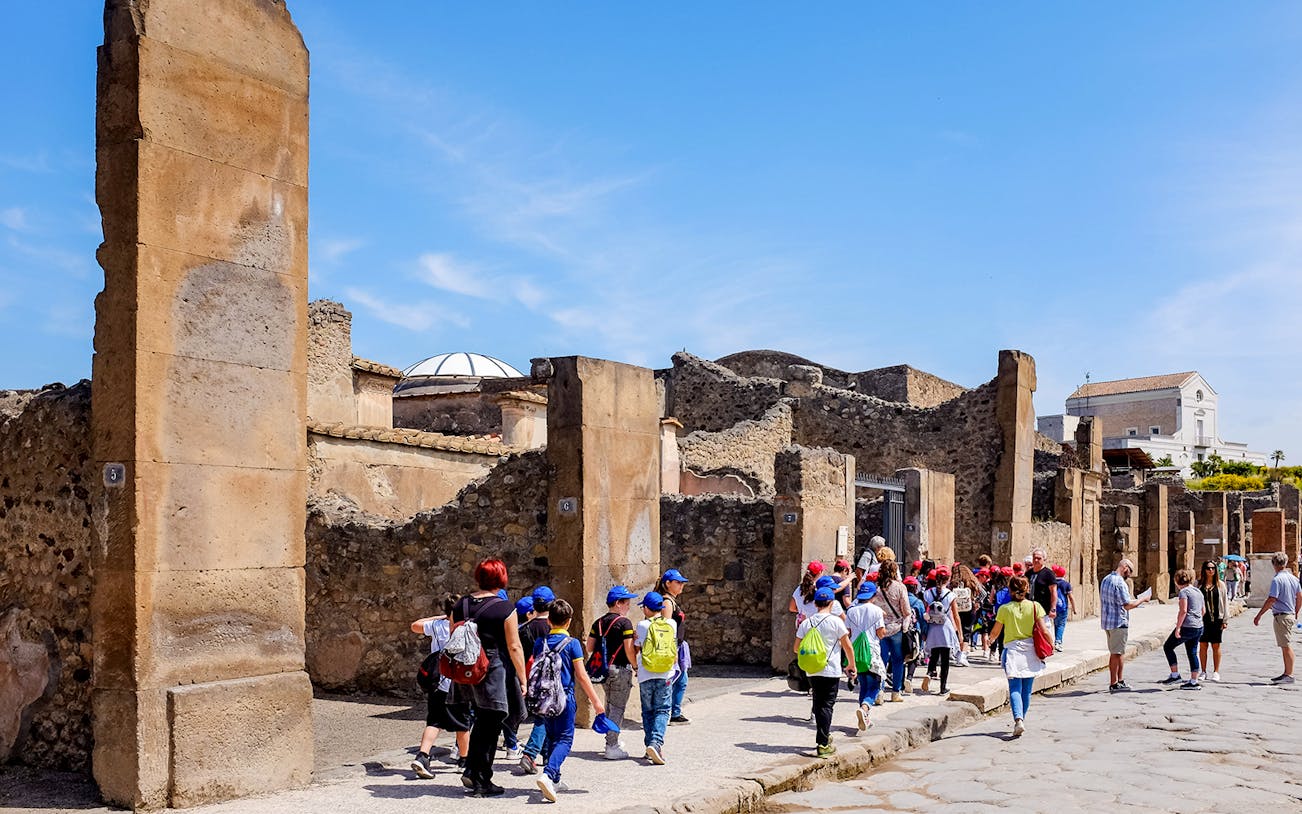 Tour group exploring ancient ruins in Pompeii, Italy.