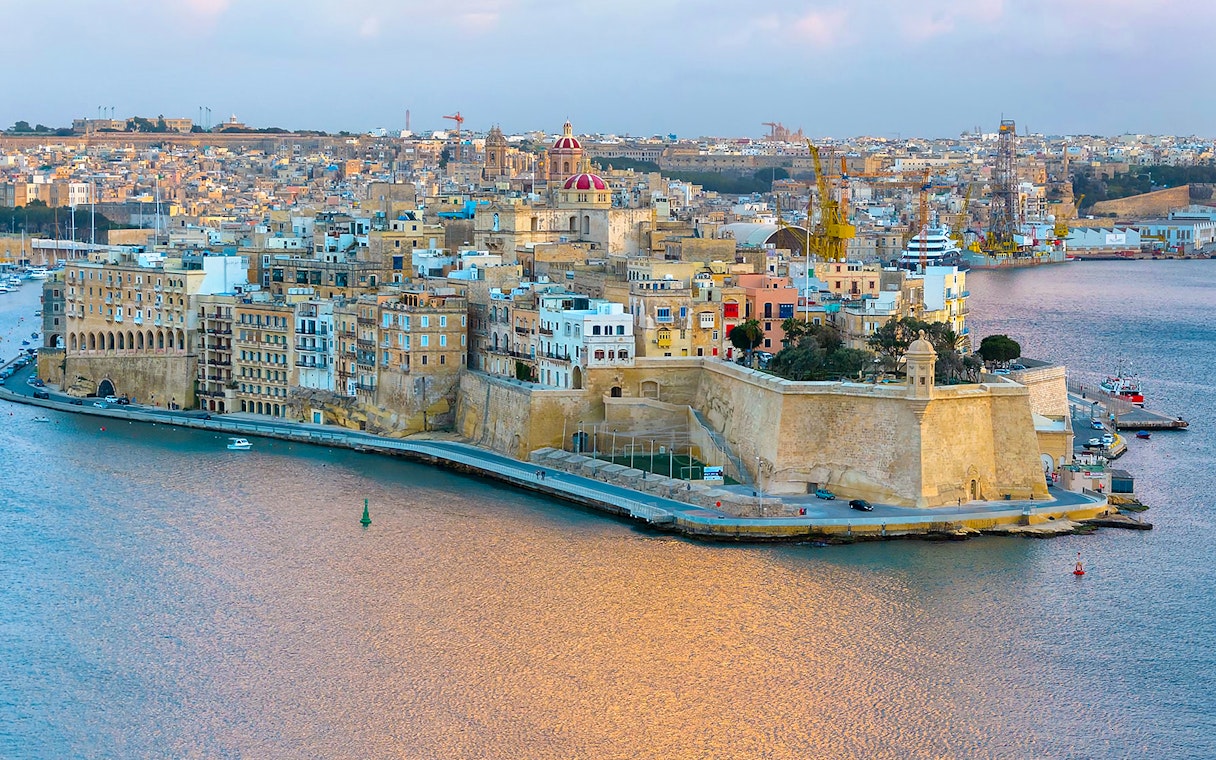 Valletta skyline and harbor view from Sliema, featuring historic buildings and waterfront.