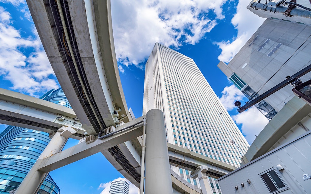 Sunshine 60 building in Ikebukuro with elevated highways and blue sky.
