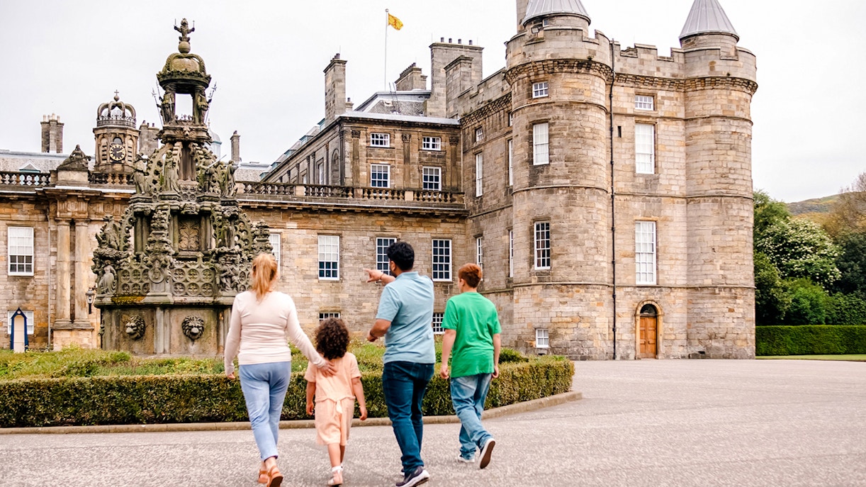 Visitors exploring the courtyard of the Palace of Holyroodhouse, Edinburgh.