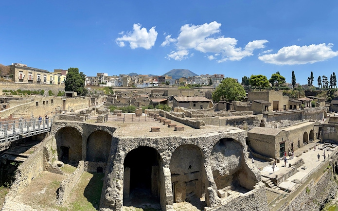 Ancient Roman ruins of Herculaneum with Mount Vesuvius in the background.