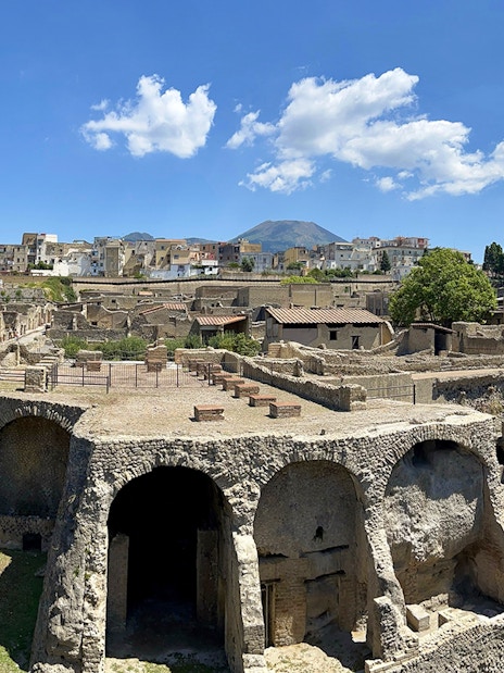 Ancient Roman ruins of Herculaneum with Mount Vesuvius in the background.