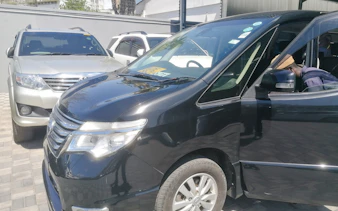 Minivan for Diani Beach transfer from Mombasa Airport, parked with driver inside.