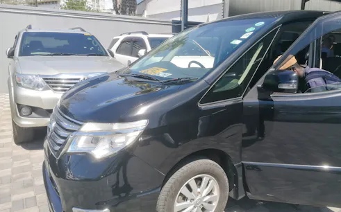 Minivan for Diani Beach transfer from Mombasa Airport, parked with driver inside.