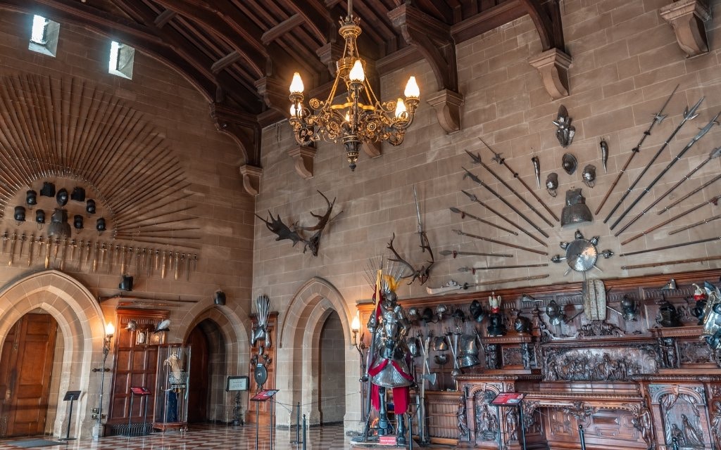 Warwick Castle interior with medieval armor and weapons display.