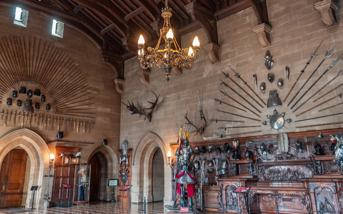 Warwick Castle interior with medieval armor and weapons display.