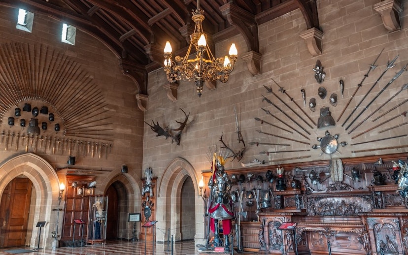 Warwick Castle interior with medieval armor and weapons display.