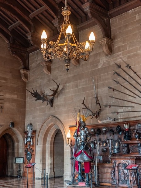 Warwick Castle interior with medieval armor and weapons display.