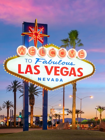 Welcome to Fabulous Las Vegas sign at sunset with palm trees.