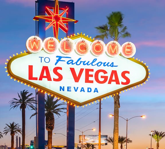Welcome to Fabulous Las Vegas sign at sunset with palm trees.