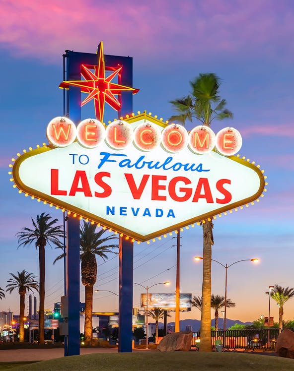 Welcome to Fabulous Las Vegas sign at sunset with palm trees.