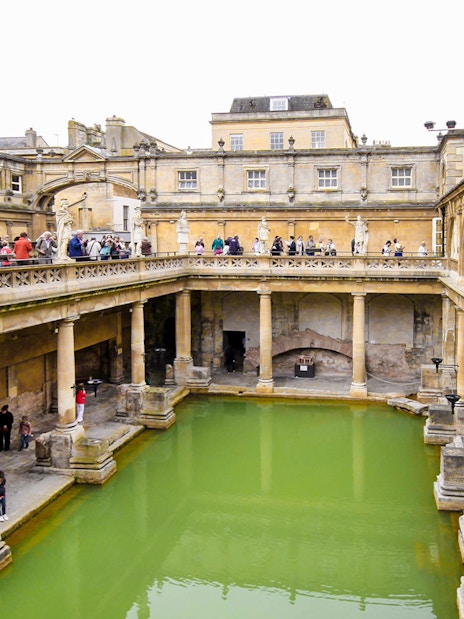 Roman Baths in Bath, England, with tourists exploring the ancient site.