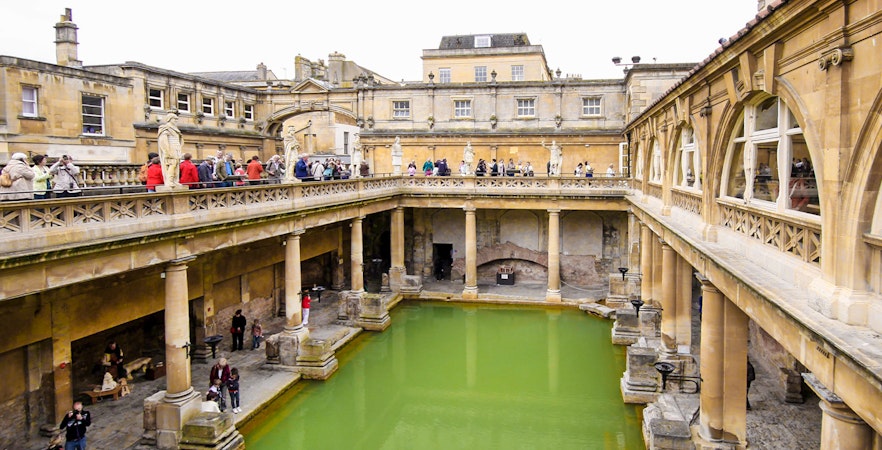 Roman Baths in Bath, England, with tourists exploring the ancient site.