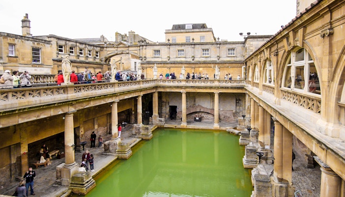Roman Baths in Bath, England, with tourists exploring the ancient site.