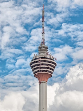 Television tower against a blue sky with clouds.