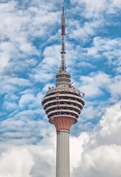 Television tower against a blue sky with clouds.