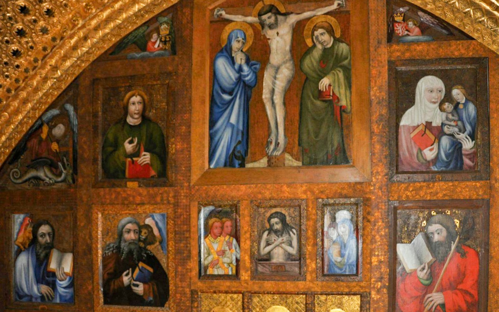 Karlstejn Castle chapel interior with religious paintings and gold detailing.