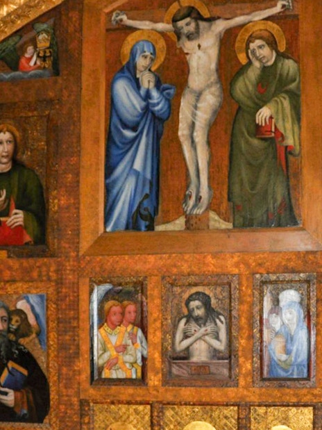 Karlstejn Castle chapel interior with religious paintings and gold detailing.