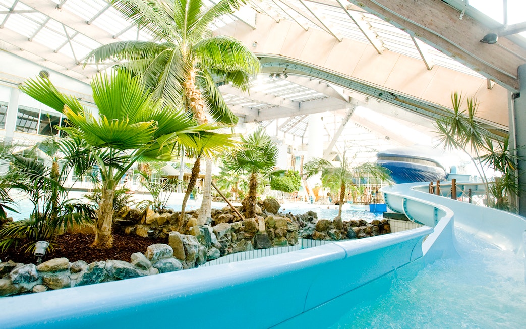 Indoor water slide and tropical plants at Aquaboulevard de Paris.