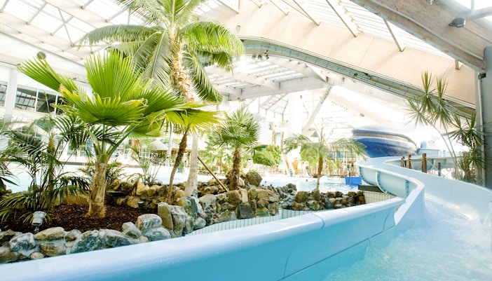 Indoor water slide and tropical plants at Aquaboulevard de Paris.