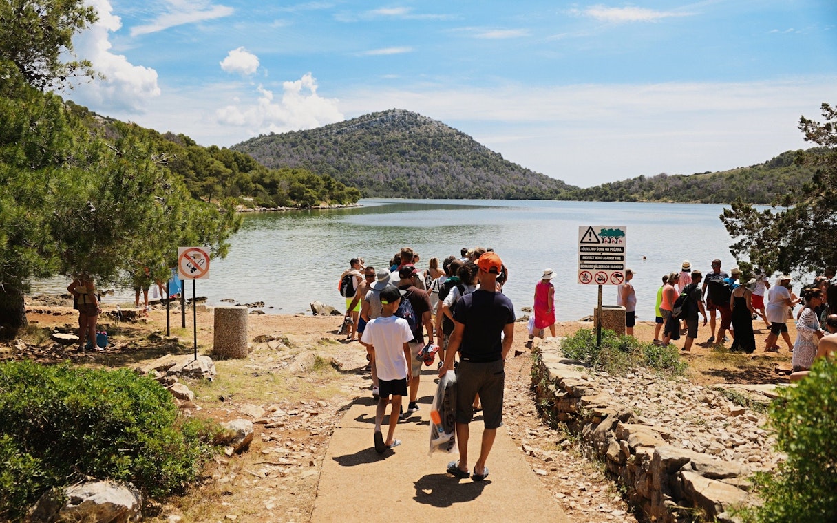 Visitors gathering at Lake Mir in Telašćica Nature Park, Croatia.