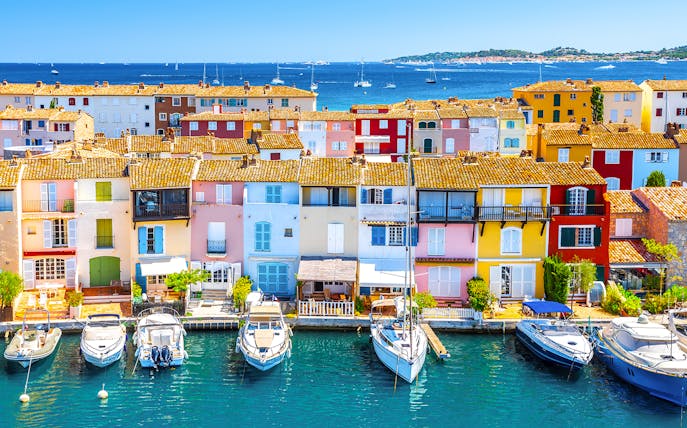 Colorful buildings and boats in Port Grimaud, France, viewed from the water.