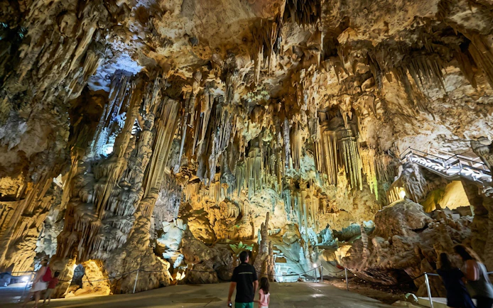 Visitors exploring the stalactites and stalagmites in the Caves of Nerja, Spain.