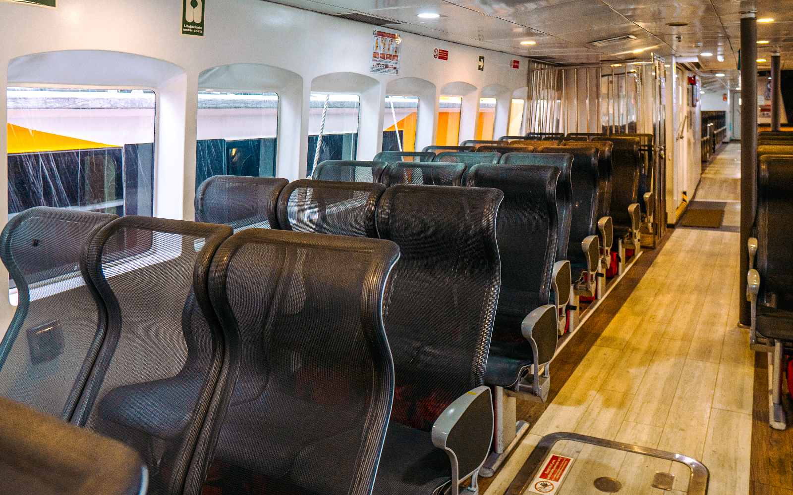 Interior seating of Singapore to Batam ferry with rows of black mesh seats.