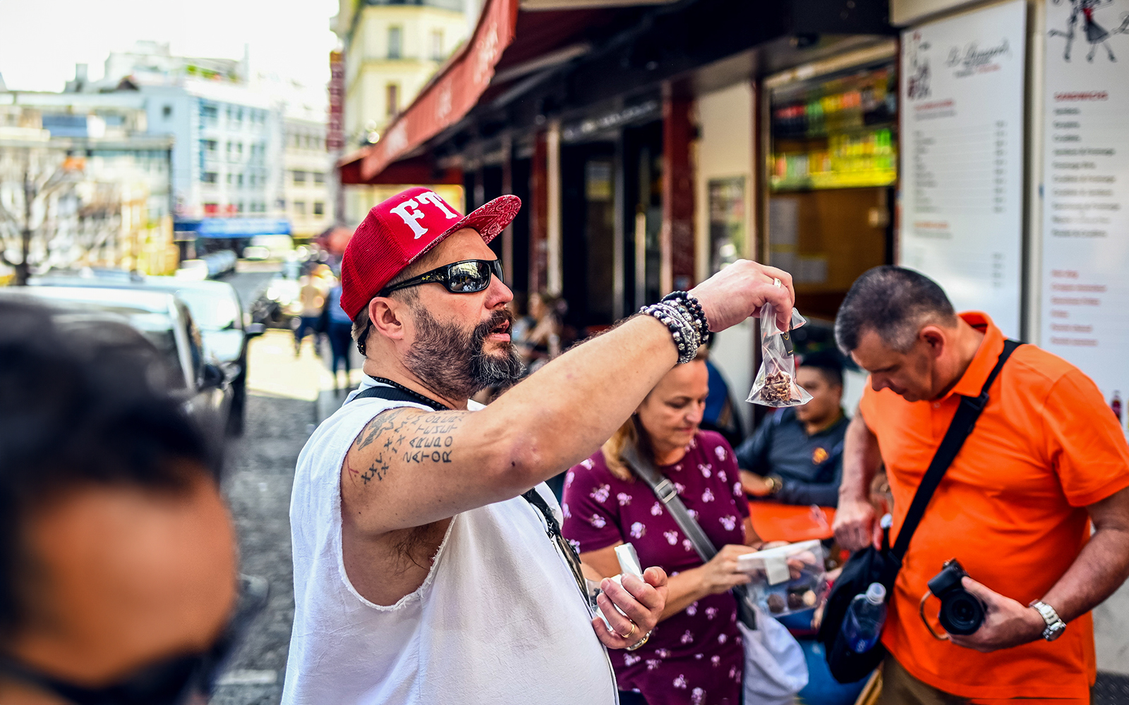 Man showcasing local snacks during a Montmartre food tour in Paris.